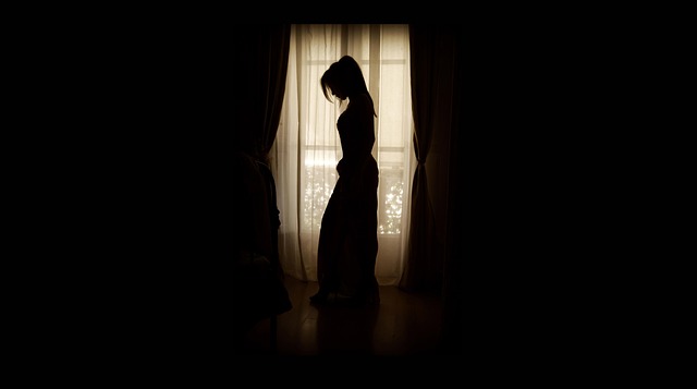 dívka stojí u okna