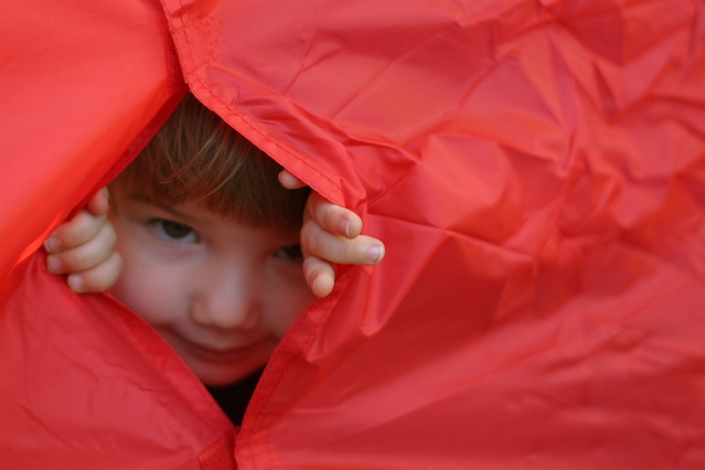 malé dítě schované v červeném stanu